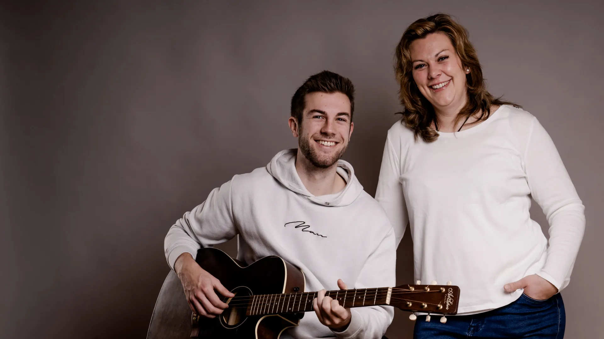 Susi und Jan im Studio, Jan sitzend mit Westerngitarre, beide lachend